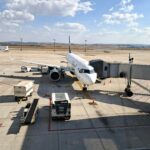 A commercial jet at a gate in Belo Horizonte, Brazil, under clear skies.